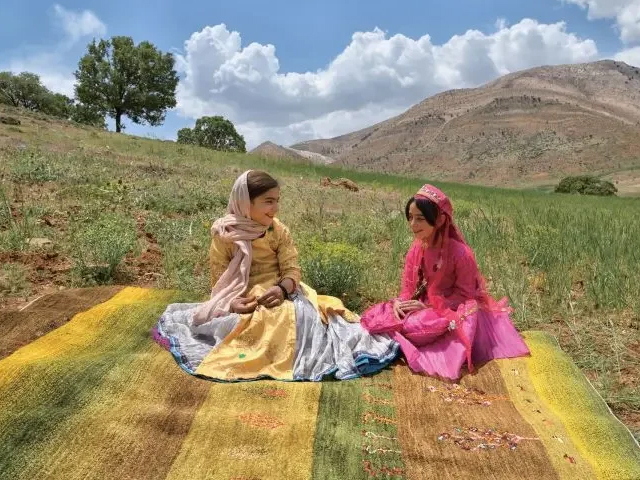 アートギャッベの上に座る織子さん