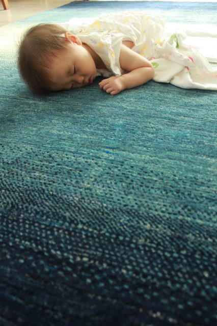 ハグみじゅうたんの上で赤ちゃんが寝ている