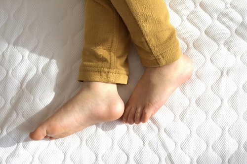 ベッドに寝る子供の足