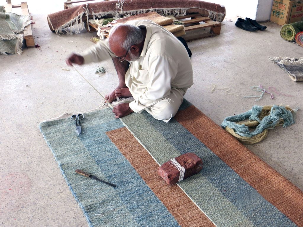 手織りの絨毯を織っている様子